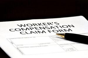 A pen lying on a workers’ compensation claim form.